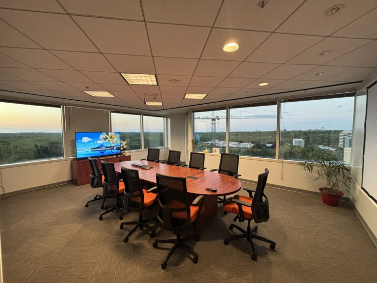 Conference Room A at golden hour with oval table and floor-to-ceiling windows in Bethesda